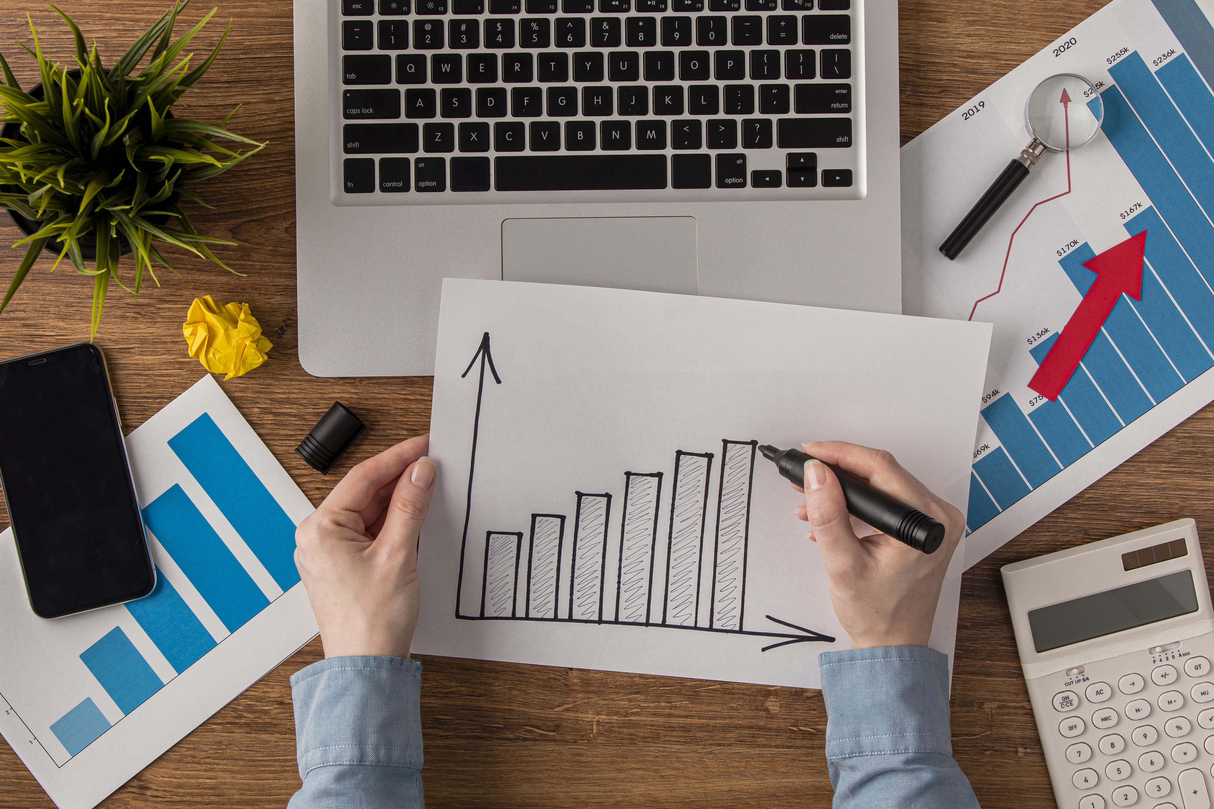 top-view-office-desk-with-calculator-growth-chart